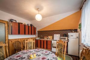 eine Küche mit einem Tisch und einem weißen Kühlschrank in der Unterkunft Privát u Bartolomeja in Štrba