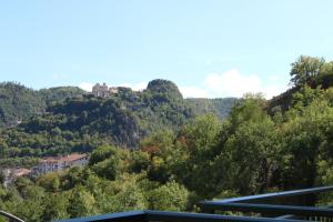 uma casa no topo de uma colina com árvores em Palia's Hotel em Laino Borgo