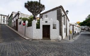 a church with a cross on the side of a street at Hotel Emblemático Arucas in Arucas