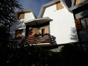 ein weißes Gebäude mit einer Veranda und einem Balkon in der Unterkunft Fiocco di Neve in Massa dʼAlbe