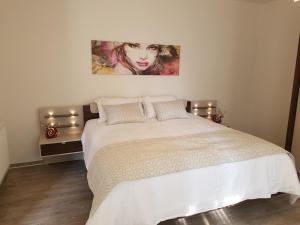 a bedroom with a bed with a painting on the wall at Arion-Thale in Thale
