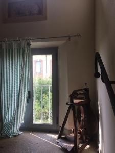 Zimmer mit einer Tür, einem Fenster und einem Stuhl in der Unterkunft Hostaria Da Ivan in Roccabianca