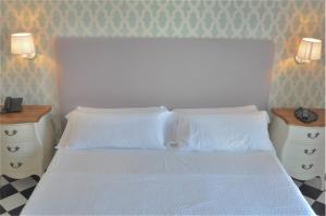 a white bed with a white comforter and pillows at Hotel Central Boutique in Marbella