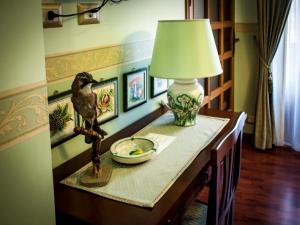 a table with a lamp and a bird statue on it at Guest House a Portapalermo in Santo Stefano di Camastra