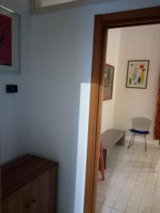 モンツァにあるArt and Home Designの椅子付きの部屋へとつながるドアのある部屋