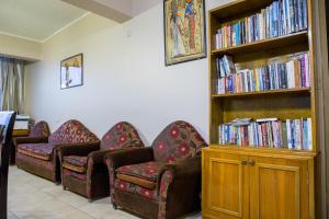 una stanza con tre sedie e una libreria con libri di Guardian Guest House a Il Cairo