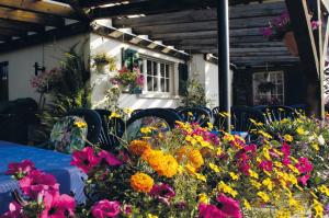 einen Tisch mit Stühlen und Blumen vor einem Gebäude in der Unterkunft Hotel Garni Sonne in Münsterlingen