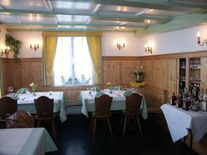 ein Esszimmer mit Tischen und Stühlen und einem Fenster in der Unterkunft Hotel Garni Sonne in Münsterlingen