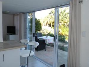 a kitchen with a sliding glass door to a patio at Agape Apartments in Somerset West