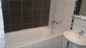 a bathroom with a bath tub and a sink at Borovets Holiday Apartments - Different Locations in Borovets in Borovets