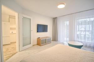 una camera con letto e TV a parete di Snow Apartment a Druskininkai