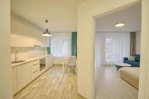una cucina e un soggiorno con divano e tavolo di Snow Apartment a Druskininkai