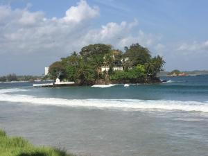 a house on an island in the middle of the ocean at Mirewon Guest in Weligama