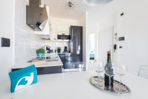 a white kitchen with two wine glasses on a counter at Attico Del Duomo in Modena