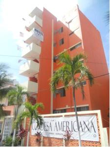 a tall orange building with a sign in front of it at Hotel Condesa Americana Acapulco in Acapulco