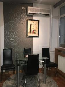 een vergaderruimte met een glazen tafel en zwarte stoelen bij Apartment Milos in Belgrado