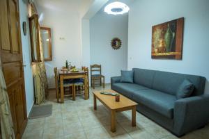 a living room with a blue couch and a table at Elea Houses in Mithymna