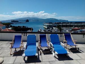 a group of blue chairs sitting on a roof at Casa do Pico Madalena in Madalena