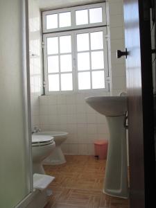 a bathroom with a toilet, sink and tub at Guesthouse da Sé in Guarda