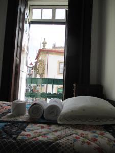 een slaapkamer met een bed met handdoeken erop bij Guesthouse da Sé in Guarda