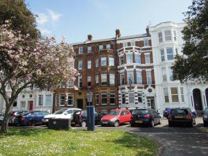 a parking lot with cars parked in front of a building at Special seafront apartment in Portsmouth