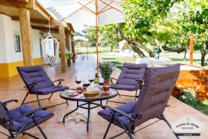 a patio with purple chairs and a table with wine glasses at Quinta da Saudade in Ponte de Sor +68 photos