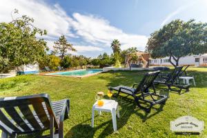 a group of chairs and a table with a glass of wine at Quinta da Saudade in Ponte de Sor