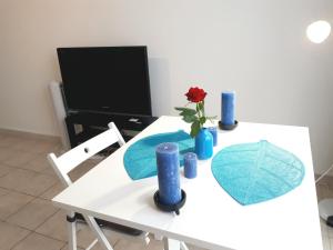 einen weißen Tisch mit einer Blume und blauen Vasen darauf in der Unterkunft Lovely place near Vieux Port in Marseille