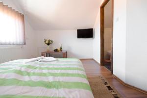 a bedroom with a green and white bed and a mirror at Guesthouse Vila Puzic in Banja Luka