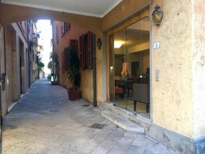 een leeg steegje met een gebouw en een tafel in de verte bij Hotel Sole in Orbetello