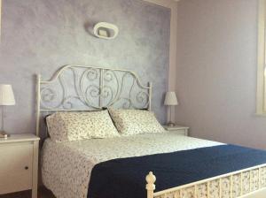 sypialnia z białym łóżkiem z niebieską kołdrą w obiekcie Sirmione, Borgo Rosa, your holiday flat w Sirmione