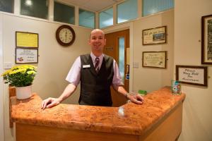 a man standing behind a counter in a office at Laguna Hotel in Bournemouth