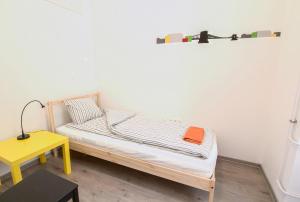 a small bed in a room with a yellow table at Pal's Mini Hostel in Budapest
