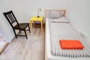 a bedroom with two beds and a chair and a table at Pal's Mini Hostel in Budapest