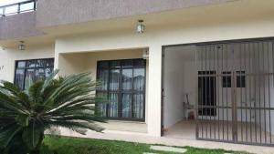 a house with a glass door and a palm tree at Bombinhas Brasil Residence II Guest House no Centro in Bombinhas