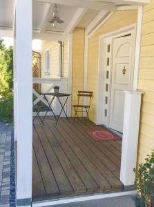 a front porch with a white door and a table at Zimmer mit Bad und Balkon in Widen