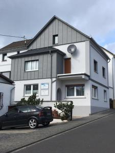 a black car parked in front of a white house at Ferienwohnung - Erhol Dich gut in Diez