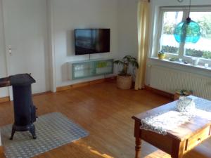 a living room with a fireplace and a tv on the wall at Ferienhaus Burkard in Epenwöhrden