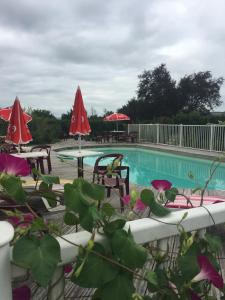 - une piscine avec des chaises, des tables et des parasols dans l'établissement Hotel Restaurant La Place, à Malay