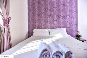 a bedroom with a bed with purple wallpaper at Outlink Skyline Minutes to JKIA airport in Nairobi