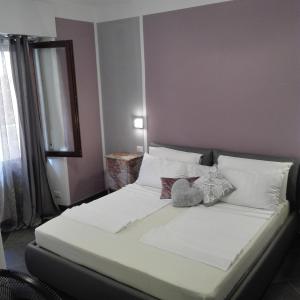 Una cama con sábanas blancas y almohadas en un dormitorio en Casa Donatella, en Malcesine