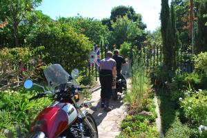 a group of people walking through a garden with a motorcycle at Kingna Lodge Montagu in Montagu