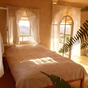 a bedroom with a large bed with a window at Hamitzpa- Desert Hosting in Ezuz in ‘Ezuz