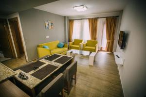 a living room with a table and yellow chairs at Turkuaz Apart in Uzungöl