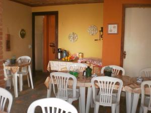 cocina con mesa y sillas blancas en Suites do Peró, en Cabo Frío