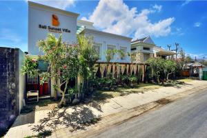 un edificio con un letrero al lado de una calle en Bali Sunset Villa, en Seminyak