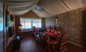 a living room with two people sitting on a couch at Dai Yuan Inn in Mengla