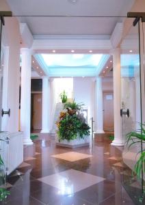 un vestíbulo con una planta en medio de un edificio en Villa Oaza, en Bela Crkva