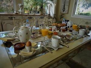 a breakfast table with eggs and drinks on it at Villa La Clef Des Champs in Chailly-en-Bière