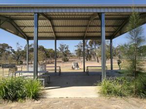 a picnic shelter with benches in a park at Augathella Motel & Caravan Park in Augathella